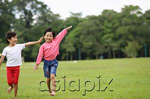 AsiaPix - Two girls running on grass, side by side, arms outstretched