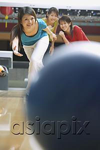 AsiaPix - Woman bowling, friends behind her watching
