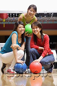 AsiaPix - Three women in bowling alley, holding bowling balls