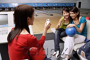 AsiaPix - Women in bowling alley, posing for friends phone camera
