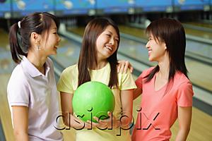 AsiaPix - Women standing side by side at bowling alley, one woman holding green bowling ball