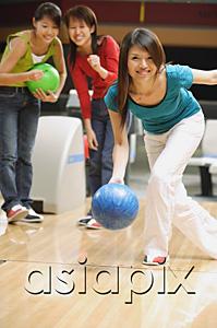 AsiaPix - Woman bowling, friends behind her, watching