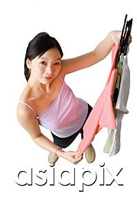 AsiaPix - Woman holding up clothes on hangers