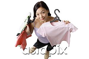 AsiaPix - Woman holding up clothes, looking at camera