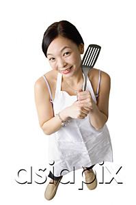 AsiaPix - Woman in apron holding kitchen utensil