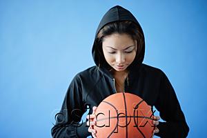 AsiaPix - Woman wearing hooded shirt, holding basketball
