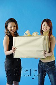 AsiaPix - Two woman carrying big gift box, smiling