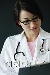 AsiaPix - Female doctor looking at clipboard