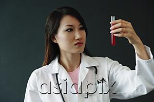 AsiaPix - Doctor looking at test tube, serious expression