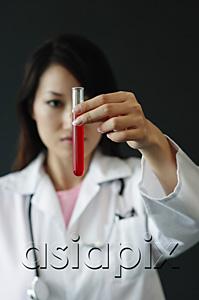 AsiaPix - Doctor holding test tube filled with red liquid, selective focus