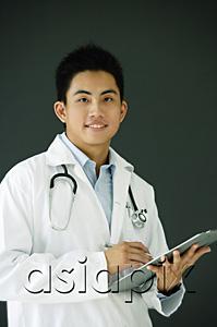 AsiaPix - Doctor holding clipboard, looking at camera