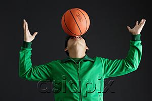 AsiaPix - Young man balancing basketball on nose