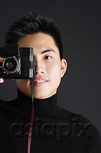 AsiaPix - Young man dressed in black looking through camera