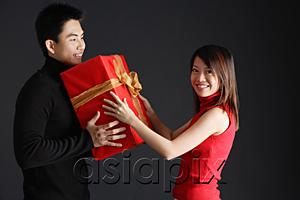 AsiaPix - Young man giving gift to woman, woman turning to smile at camera