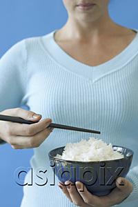 AsiaPix - Woman holding bowl of rice and chopstick, cropped image