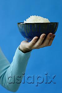 AsiaPix - Woman holding bowl of rice in one hand