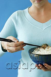 AsiaPix - Woman holding bowl of rice in one hand and chopsticks in the other