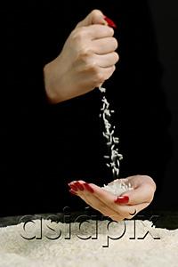 AsiaPix - Woman pouring rice into cupped hands