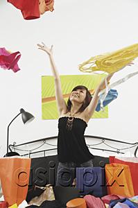 AsiaPix - Girl kneeling on bed, throwing clothes in the air