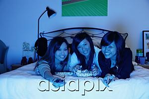 AsiaPix - Three girls in bedroom, lying on bed, smiling at camera