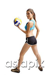 AsiaPix - Young woman holding volleyball, looking over shoulder