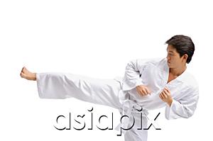 AsiaPix - Young man in martial arts uniform, kicking