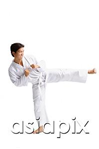 AsiaPix - Young man wearing martial arts uniform, standing on one leg