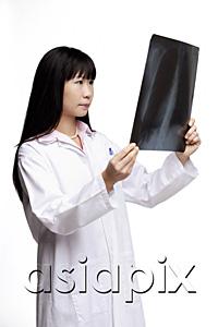 AsiaPix - Woman in lab coat, looking at X-ray