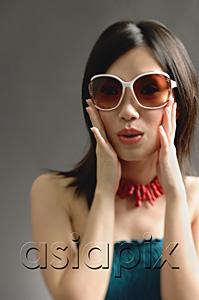 AsiaPix - Woman wearing large sunglasses, hands on face