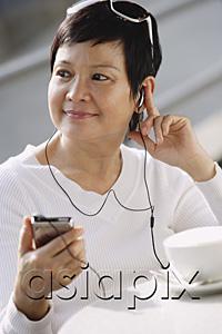 AsiaPix - Woman listening to music from an MP3 player