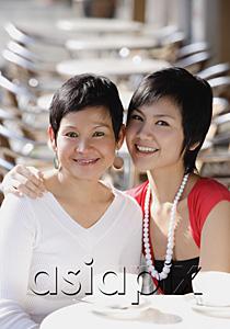 AsiaPix - Mother and adult daughter in cafe, smiling at camera, portrait
