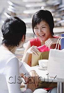 AsiaPix - Two women at cafe with shopping bags, over the shoulder view