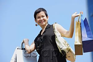 AsiaPix - Mature woman carrying shopping bags, smiling at camera