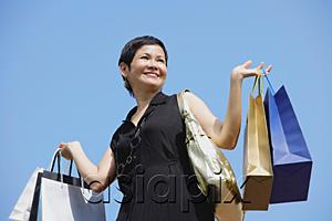 AsiaPix - Mature woman carrying shopping bags, looking away