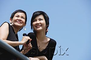 AsiaPix - Women side by side, smiling, looking away