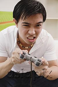 AsiaPix - Man holding video game console, grimacing