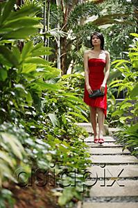 AsiaPix - Woman walking along garden path, wearing red dress