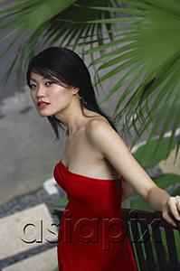 AsiaPix - Woman in red dress, leaning on railing, looking at camera