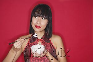AsiaPix - Woman against red background, holding bowl of rice