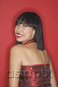 AsiaPix - Woman against red background, looking over shoulder, smiling