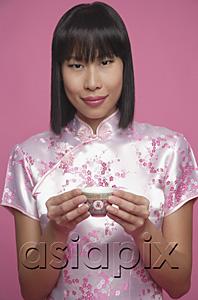 AsiaPix - Woman in pink cheongsam, holding Chinese tea cup, portrait