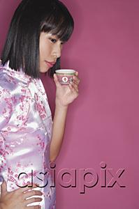 AsiaPix - Woman drinking Chinese tea, hand on hip