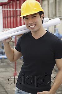 AsiaPix - Young man wearing hardhat, carrying blueprints