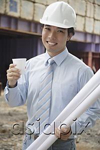 AsiaPix - Businessman wearing hardhat, carrying blueprints and a cup