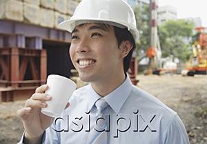 AsiaPix - Businessman wearing hardhat, drinking from disposable cup