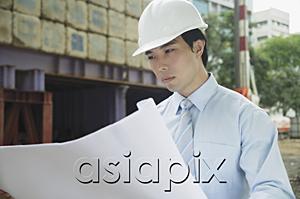 AsiaPix - Businessman looking at blueprints