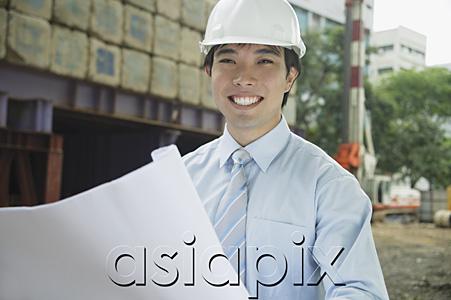 AsiaPix - Businessman with blueprints, smiling at camera