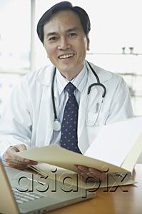 AsiaPix - Doctor smiling at camera, holding folder