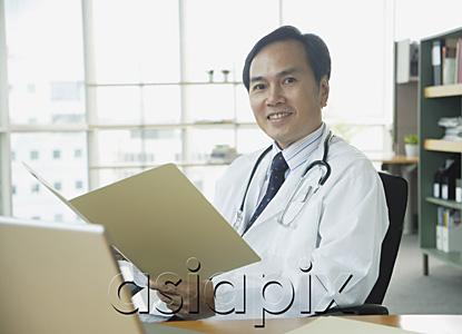 AsiaPix - Doctor sitting in office, smiling at camera