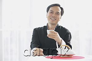 AsiaPix - Man holding teacup, smiling at camera